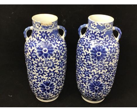 A pair of Chinese blue and white porcelain vases of cylindrical form, each with twin handles and decorated in cobalt blue wit