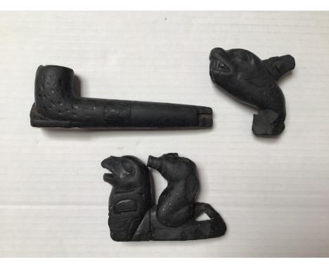 Three black jet stone carvings, comprised of a pipe and two wild animals, one ridden by figure of a man. possibly Native Amer