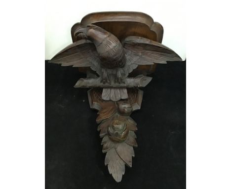 A Victorian carved oak wall bracket, supported by an eagle on perch above fruit and foliage, 43 cm high 