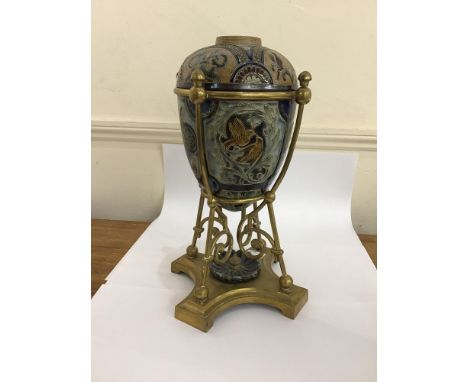 A Doulton Lambeth stoneware and brass oil lamp, the egg shaped body incised with panels of foliage, birds and mythical beasts