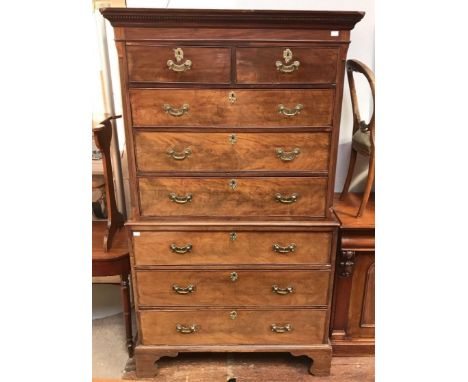 A George III walnut chest on chest, the top section with shaped cornice and dentil moulding, above a bank of two short, over 