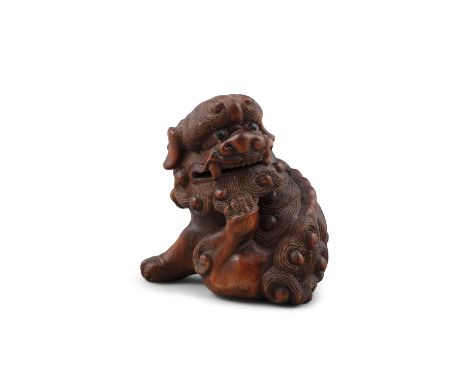 *YASUYUKI保之: A WOOD 'KARASHISHI' KATABORI NETSUKE Japan, Edo period Pierced with two himotoshi. An inlaid mother of pearl med