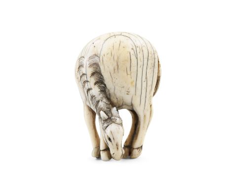 *AN IVORY 'GRAZING HORSE' KATABORI NETSUKE Japan, Edo period Unsigned. Pierced with two himotoshi. H: 5,6 cm Weight: 27 grams