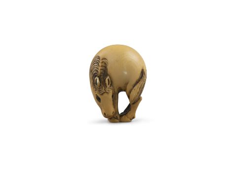 *A SIGNED IVORY KATABORI NETSUKE OF A GRAZING HORSE Japan, 19th century Pierced with two himotoshi. With a signature to the b