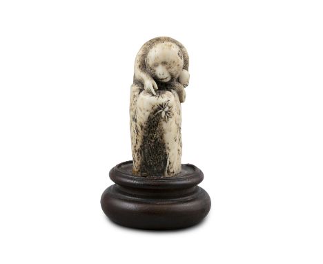 *A STAG ANTLER OKIMONO OF A MONKEY WITH A SPIDER Japan, Meiji period Affixed to a wooden stand. H (total): 8,5 cm Gross weigh