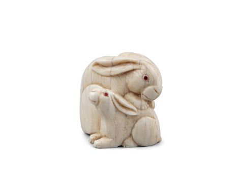 *A SIGNED IVORY 'TWO COILED RABBITS' KATABORI NETSUKE Japan, 19th century With inlaid eyes. Pierced with two himotoshi. With 