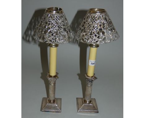 An Edwardian silver pair of Corinthian column candlesticks Sheffield 1907 with spring loaded candlestick extenders and pierce