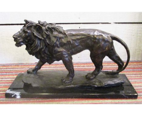 BRONZE, of a striding lion, on a black marble base, 26cm H x 45cm W x 15cm D.