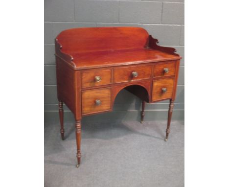 A Regency mahogany Gentleman's dressing stand with galleried back, drawers and on turned legs and casters  