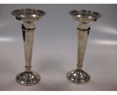 A pair of silver trumpet vases with cupped necks and pierced rims  