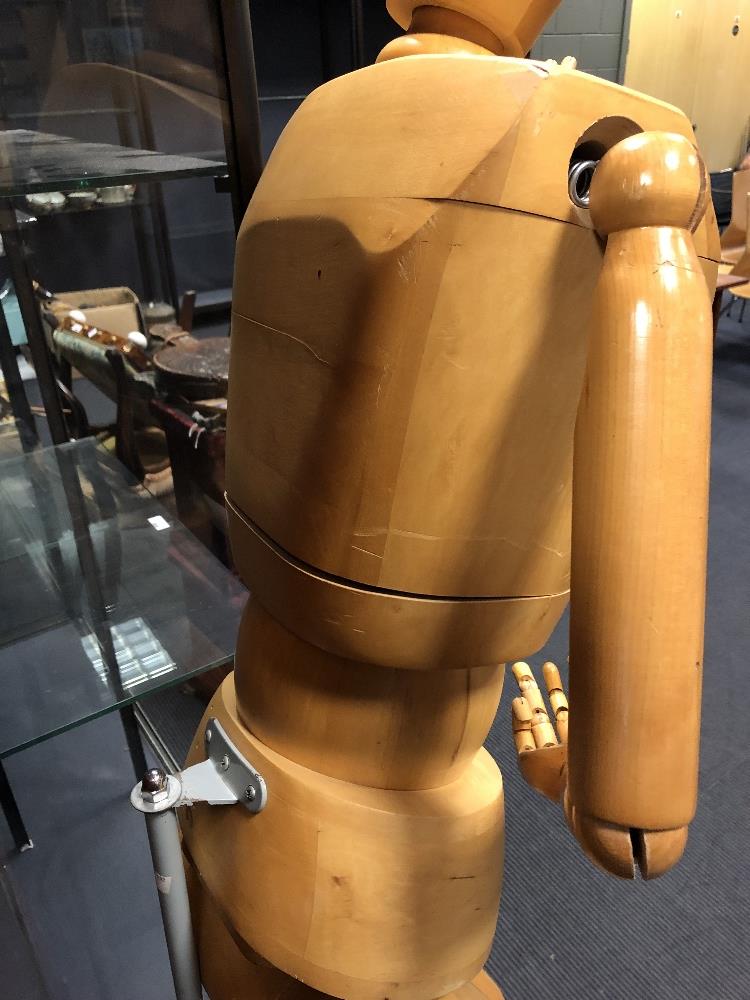 A 20th century carved wood full size mannequin, with articulated joints, mounted to a telescopic