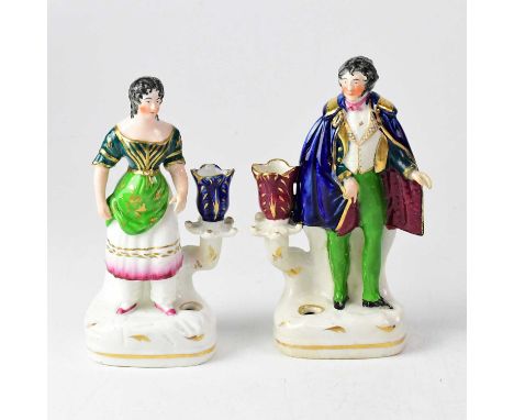 A pair of 19th century Staffordshire figural inkwells/candlesticks, one modelled as a gentleman wearing a cloak, the other as