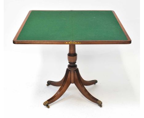A George III mahogany fold-over card table with baize top, on a barrel turned support and quadruped reeded base, with castors