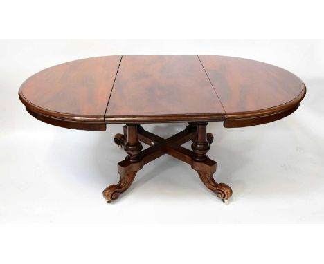 A Victorian mahogany circular extending table with single additional leaf, raised on four turned supports to cross-stretchere