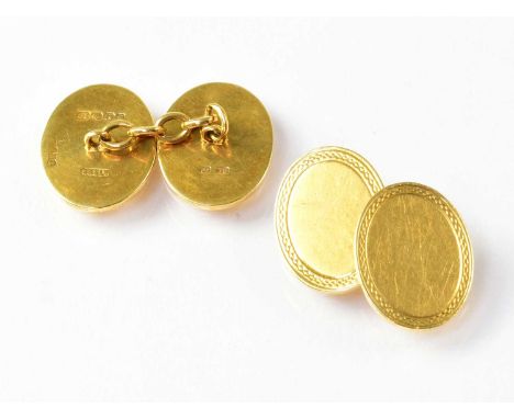 A pair of 18ct gold cufflinks of oval form, with engine turned border, stamped '18', combined approx. 16.2g.
