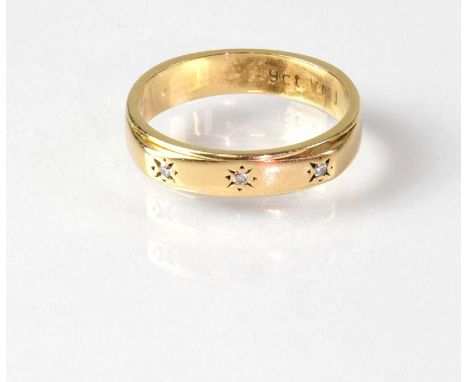 A 9ct gold wedding band set with three diamond chips, stamped '9CT', size K, approx. 2.6g.