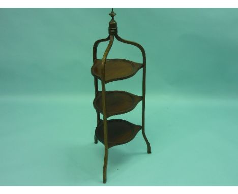 An Edwardian mahogany Cake Stand, with boxwood inlay, turned and shaped shelves surmounted by a turned finial, 38in (96.5cm) 