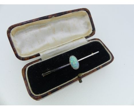 An 18ct yellow gold and platinum Bar Brooch, the centre set with an oval opal, the stone 20mm long, in fitted leather case.