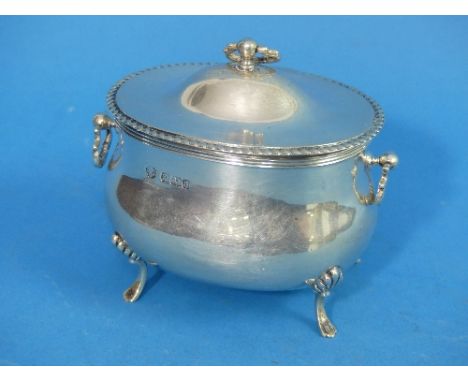 An Edwardian silver Tea Caddy, by William Hutton &amp; Sons Ltd. hallmarked Sheffield 1908, of oval form with two ring handle