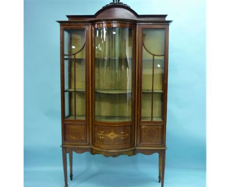 An Edwardian mahogany marquetry inlaid bow-front display cabinet, with box-wood and ebony stringing, an arched crest and two 