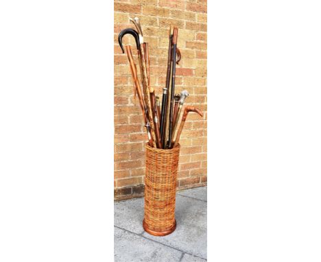 THIRTEEN ASSORTED WALKING STICKS, CANES AND HIKING STICKS in a cylindrical wicker stick stand