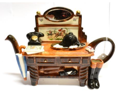 A NOVELTY HUNTING TEAPOT in the form of a dresser, decorated with hunting boots, rosette and hunt scene, the lid with riding 