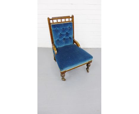 A Victorian mahogany framed nursing chair having a moulded top rail above button back and stuff over seat raised on turned su