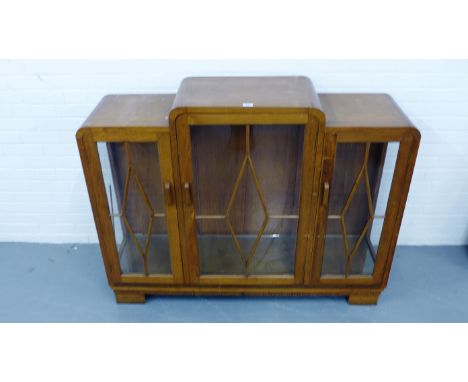 A 1930's style mahogany display case having three glazed panel doors enclosing shelves raised on squared supports, 138 x 109c