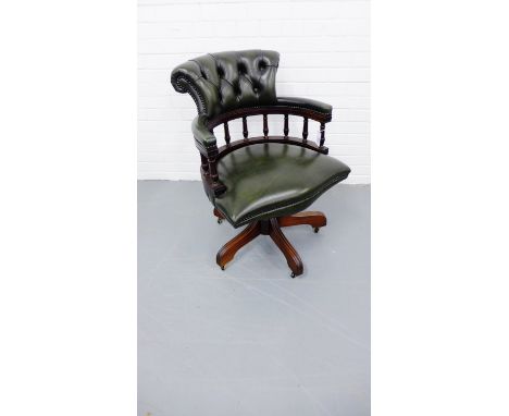 A reproduction office swivel chair having a padded button back over gallery top and padded seat upholstered in green leather 