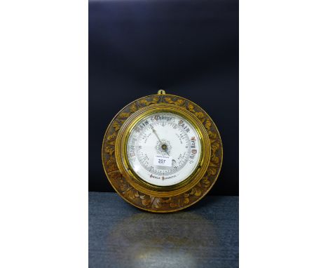 A carved oak framed aneroid wall barometer, 32 cm diameter 