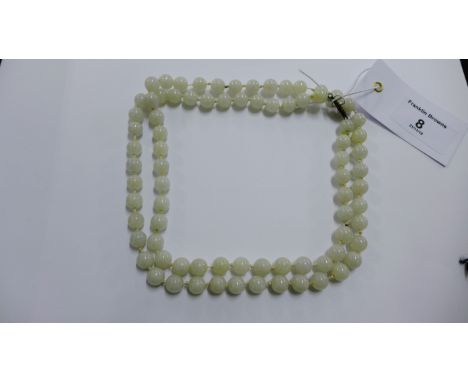 A strand of pale green jade beads with a silver clasp fastening 