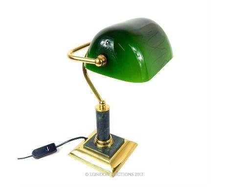 A brass banker's lamp with a green glass adjustable shade, raised on a green marble cylindrical stem with green marble to the