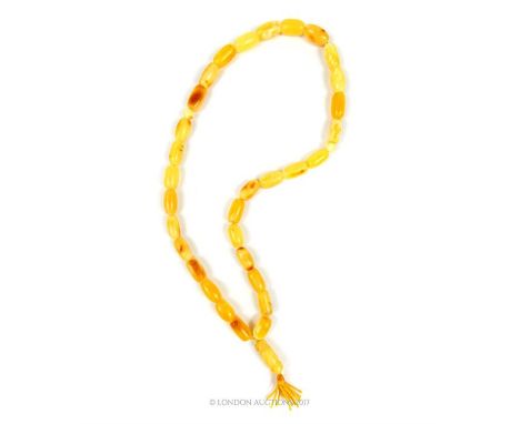 A natural, yellow amber beaded prayer bead necklace comprising of thirty-four beads with a bead and tassel finial, Length: 32