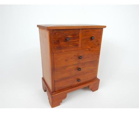 A pine apprentice piece chest of two short over three long drawers, raised on shaped bracket supports, 23 x 18 x 10cm.