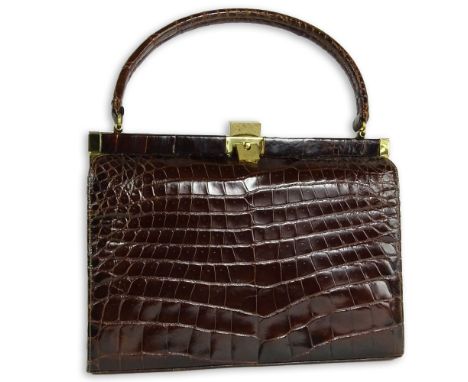 Vintage Alligator Handbag. Rich brown color with gold tone hardware. Leather interior. Unsigned. Good gently used condition. 