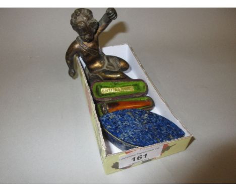 Small lapis lazuli mounted navette shaped trinket box, a small bronze figure of seated putto and a silver mounted amber chero