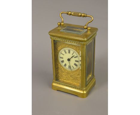 Edwardian gilt brass carriage clock, the circular dial with Roman numerals and ornate cast gilt brass back plate 