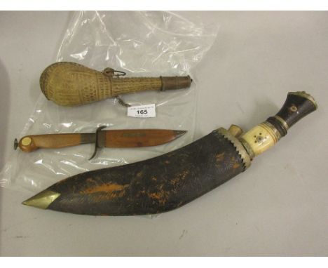 Indian kukri with bone and hardwood grip in a leather scabbard, a native stitched leather gourd shaped shot or powder flask w