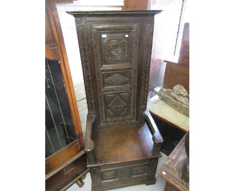 Tall and narrow antique carved oak settle with a three panel back above a box seat and a two panel front raised on bracket fe