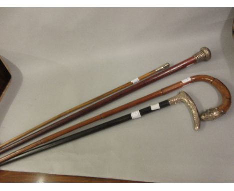 Two silver mounted walking sticks, another with white metal mount and a swagger stick 