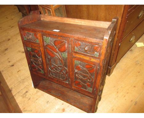 20th Century Art Nouveau style wall bracket with an arrangement of doors and drawers with carved decoration and single shelf 