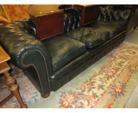 20th Century Chesterfield button back three seat sofa in dark green, with loose cushions and bun supports 