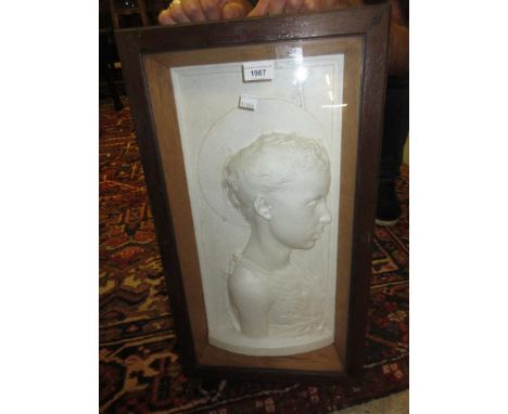 Late 19th / early 20th Century plaster plaque, profile portrait of a young saint, in an oak glazed box frame, 24ins x 13.5ins
