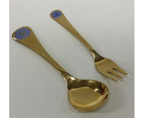 GEORG JENSEN: A silver gilt child's spoon together with matching fork. Approx. 67 grams. Est. £50 - £80.