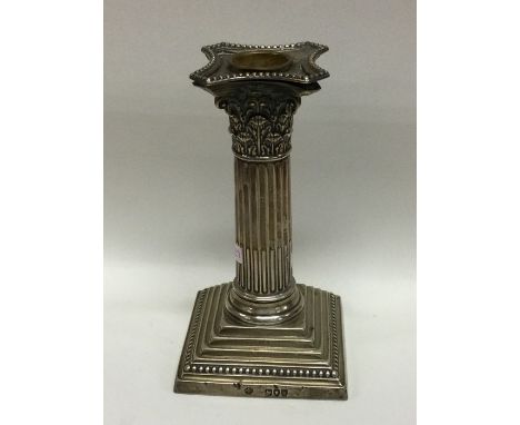 An Edwardian silver Corinthian column candlestick on stepped base. London. By SH. Approx. 500 grams. Est. £50 - £80.
