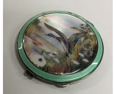 A circular silver and enamelled compact decorated with a duck. Birmingham. By Henry Davis. Approx. 77 grams. Est. £50 - £80.