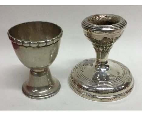 A small silver dwarf candlestick together with an egg cup. Approx. 36 grams. Est. £10 - £20.