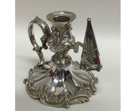 A good quality Victorian silver chamber stick decorated with scrolls and flowers together with matching extinguisher. London 