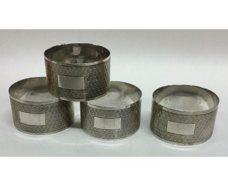 A good set of four silver engine turned napkin rings. Sheffield. By EV. Approx. 76 grams. Est. £80 - £120.