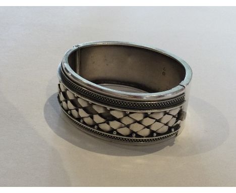 A Victorian silver hinged bangle with concealed clasp. Approx. 37 grams. Est. £30 - £40.
